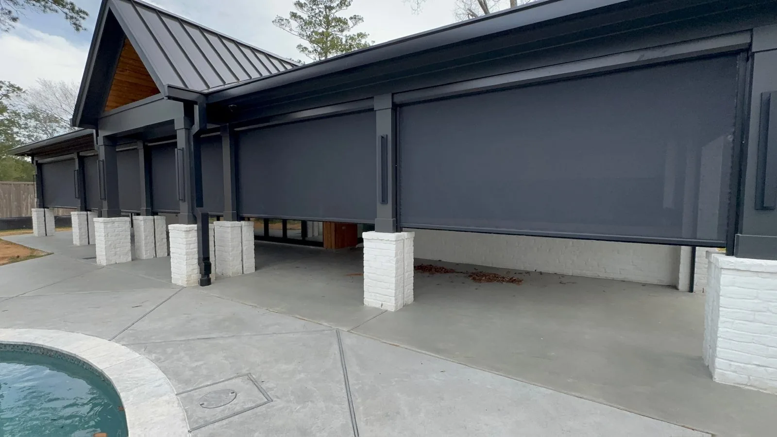Dark exterior shades integrated into a modern covered patio